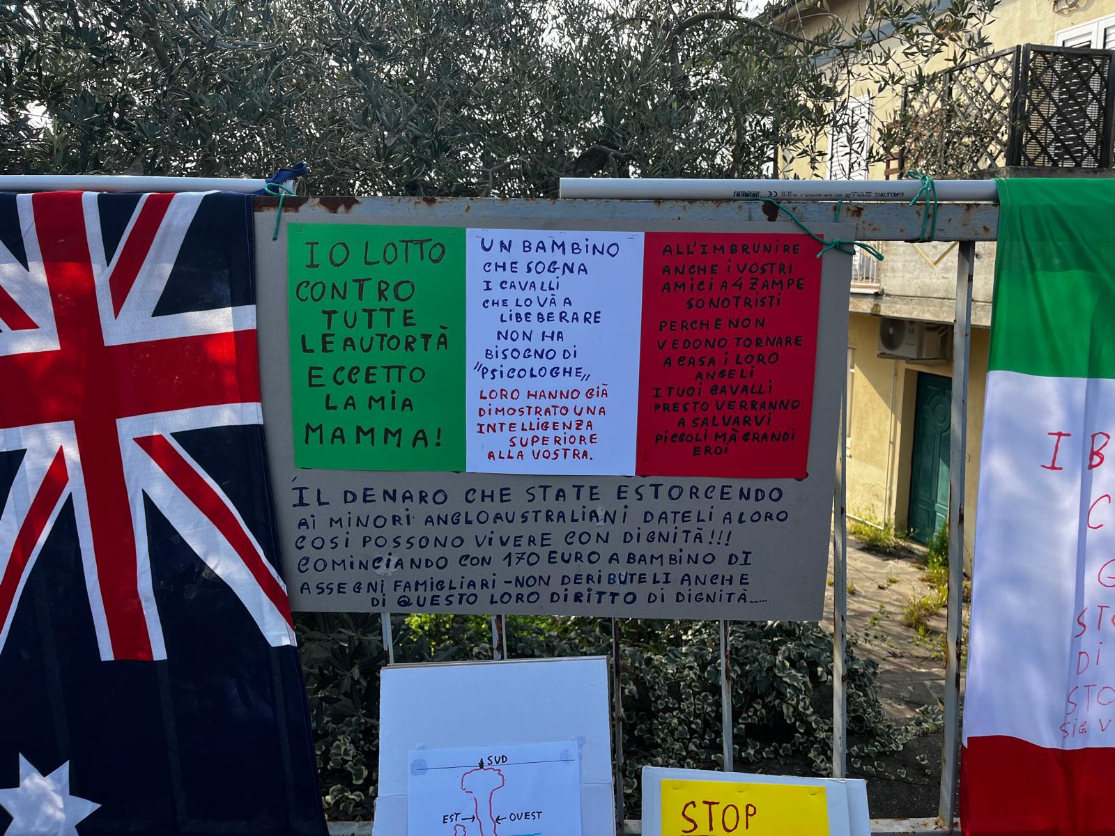 family in the woods sit in outside foster home signs and toys for the children